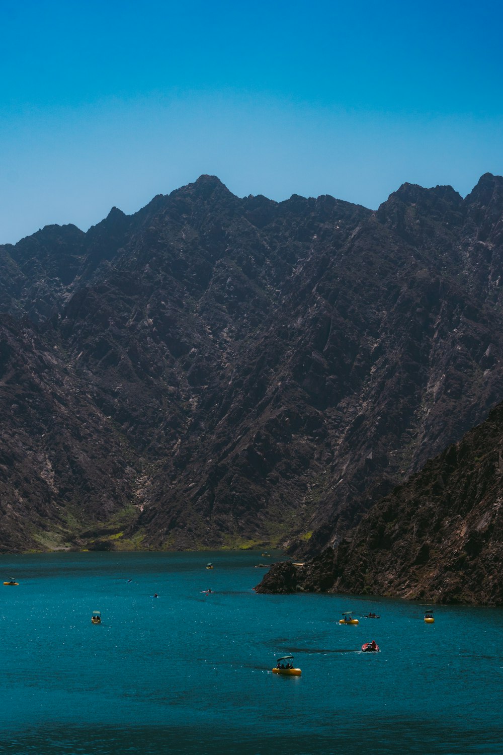 a body of water surrounded by mountains under a blue sky