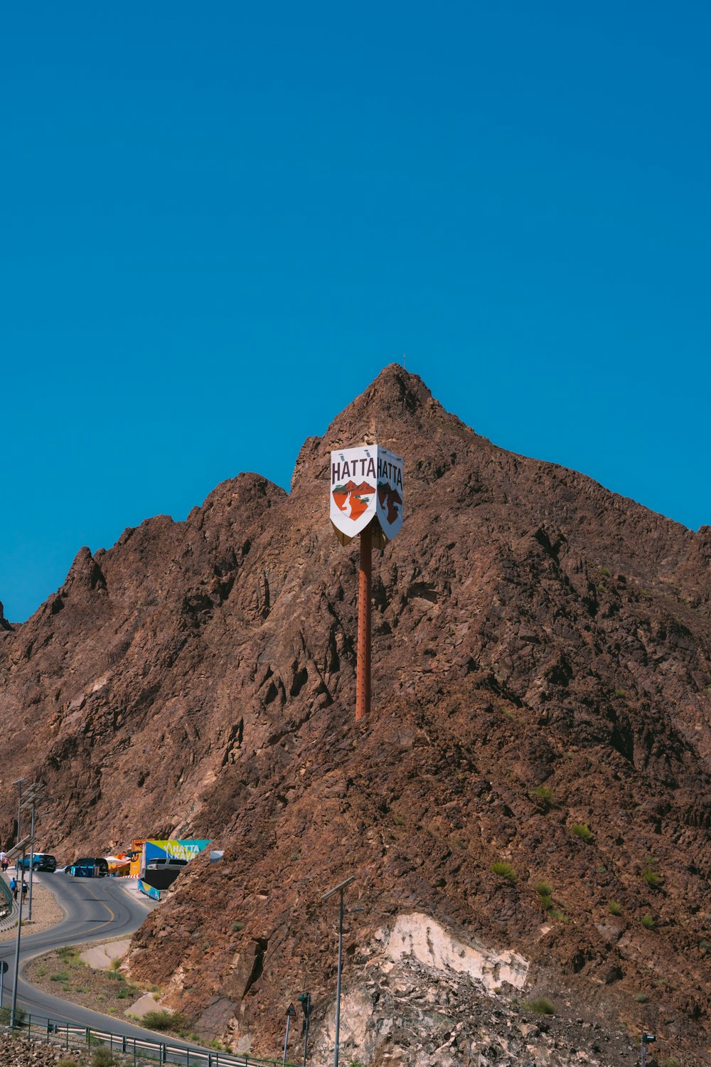 a sign on a pole in front of a mountain