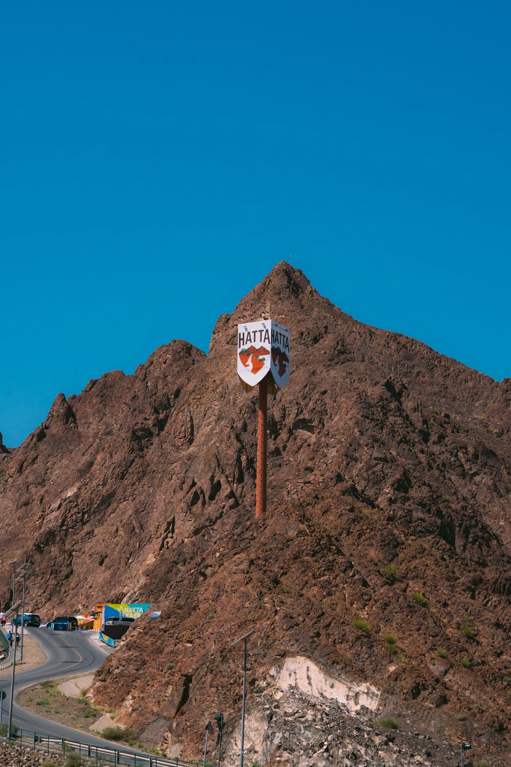 un letrero en un poste frente a una montaña