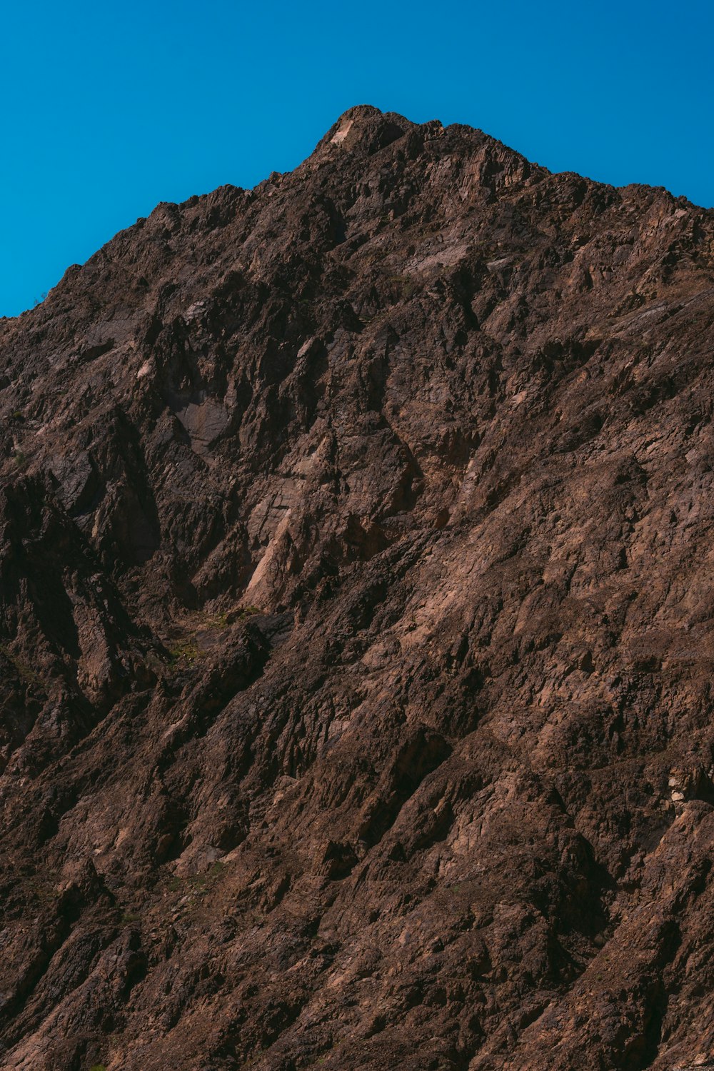 una ladera de montaña con un cielo azul en el fondo