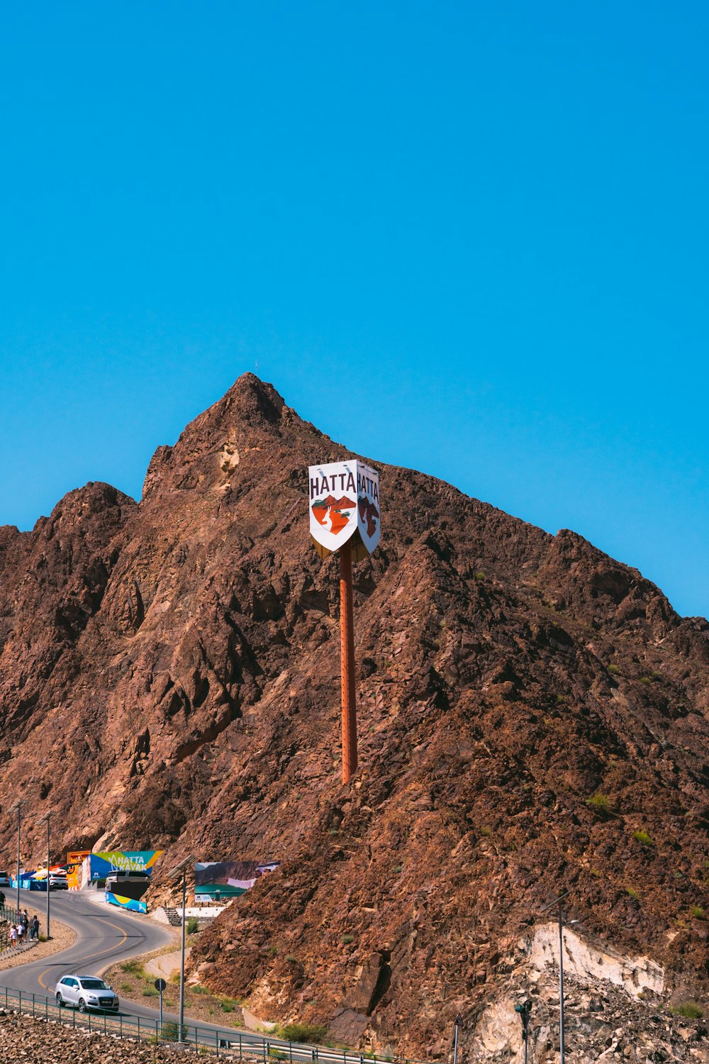 a street sign on a pole in front of a mountain