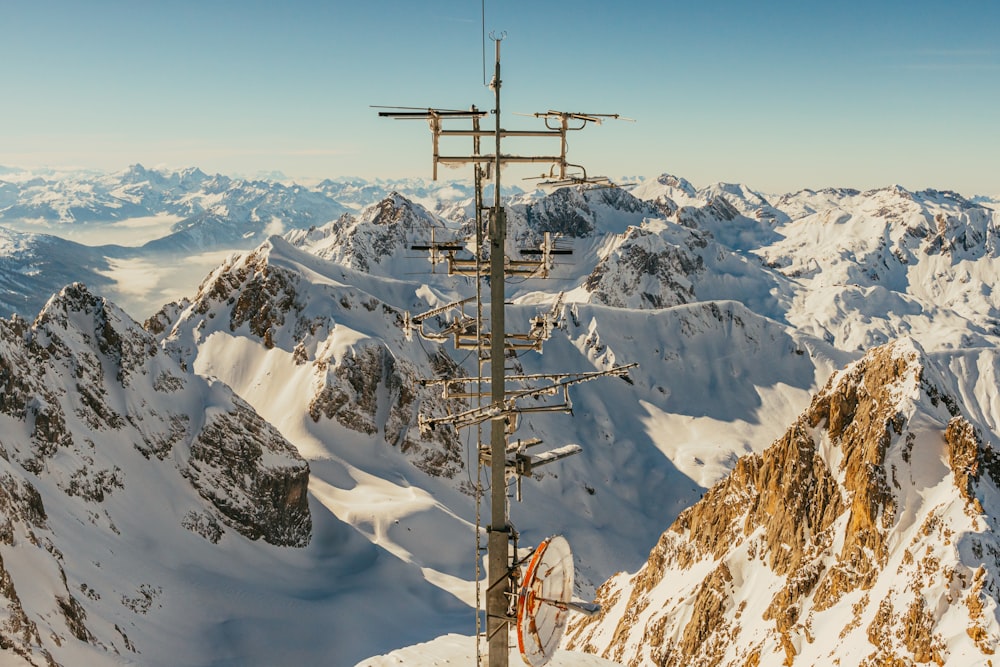 a very tall tower sitting on the side of a snow covered mountain