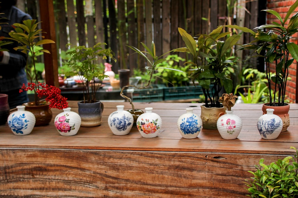 a group of vases sitting on top of a wooden table