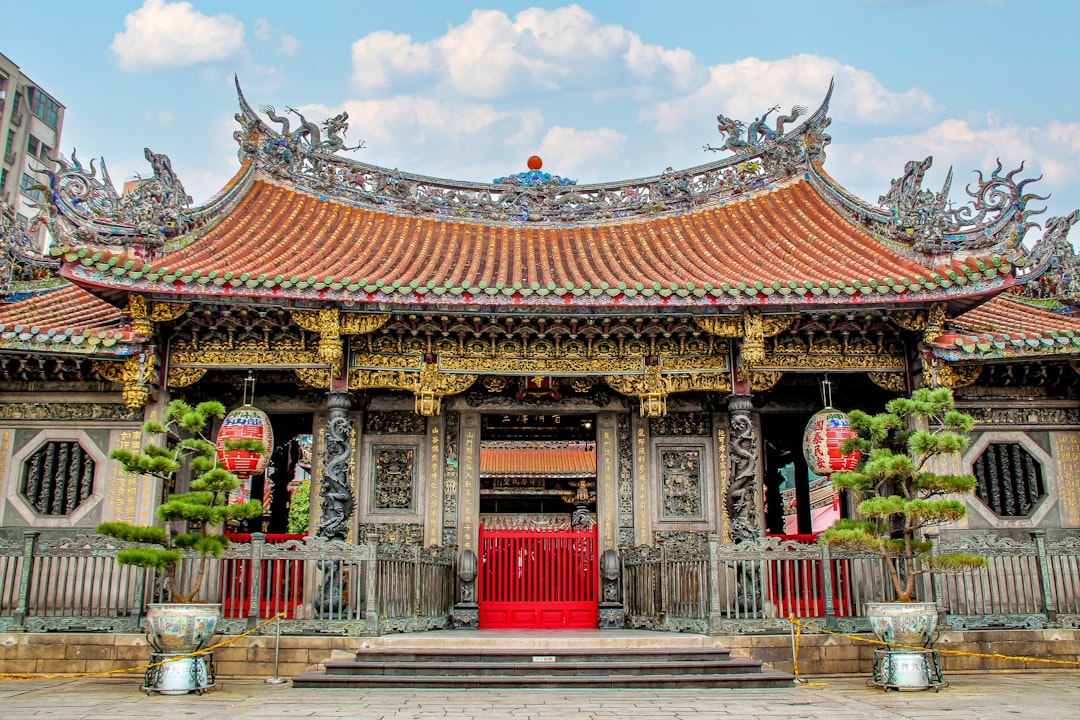 Taiwanese temple with ancient roof with dragon, blue sky and white clouds. Longshan temple. Taipei. ,Chinese architecture