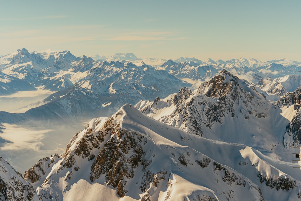 a mountain range covered in snow with mountains in the background