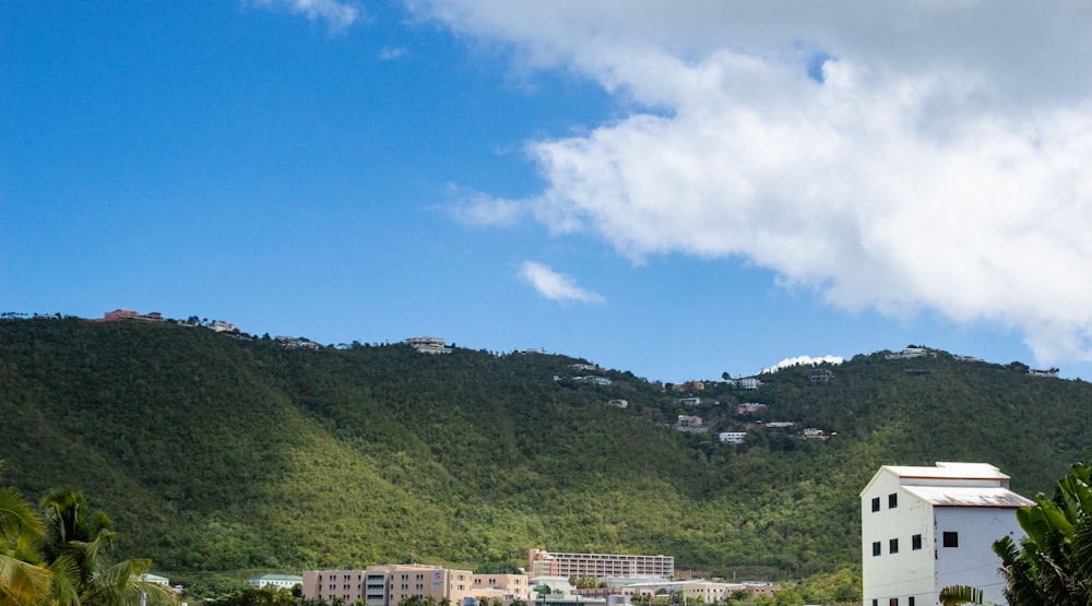 a white building sitting on top of a lush green hillside