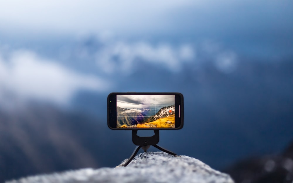 a person taking a picture with a cell phone on a tripod