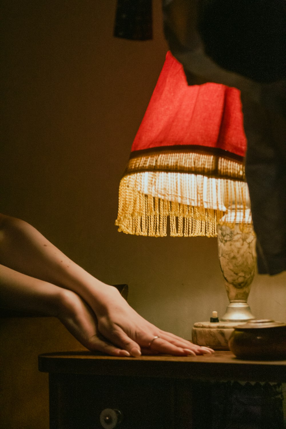 a person's foot resting on a table next to a lamp
