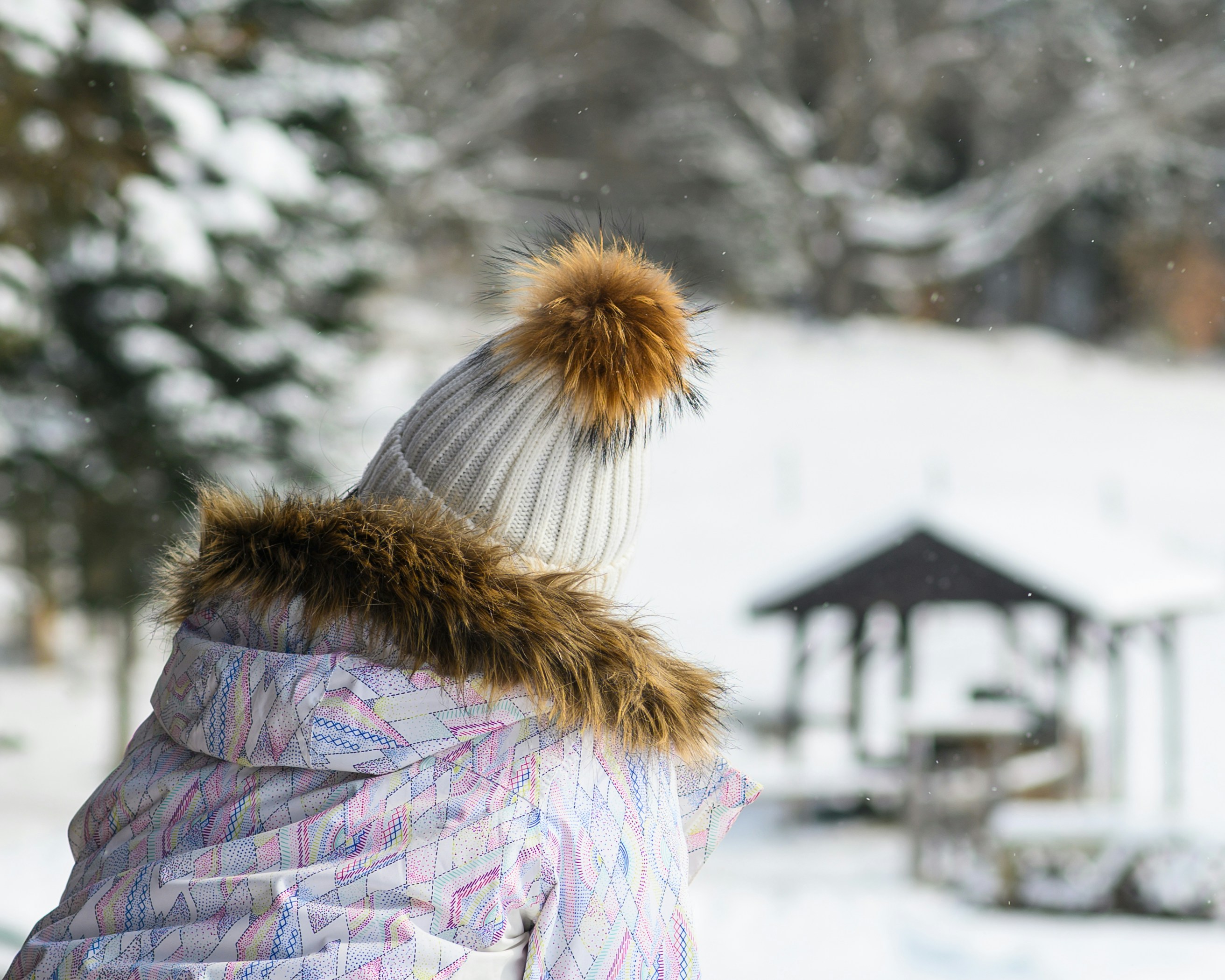 una persona che indossa un cappotto e un cappello nella neve