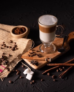 a cup of coffee and cinnamons on a table