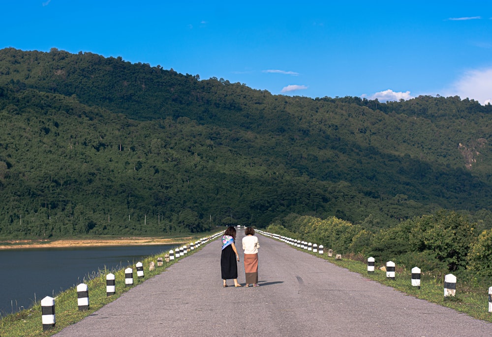 a couple of people that are standing on a road