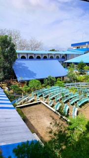 An outdoor panel discussion under clear blue skies, with attentive audience members listening.