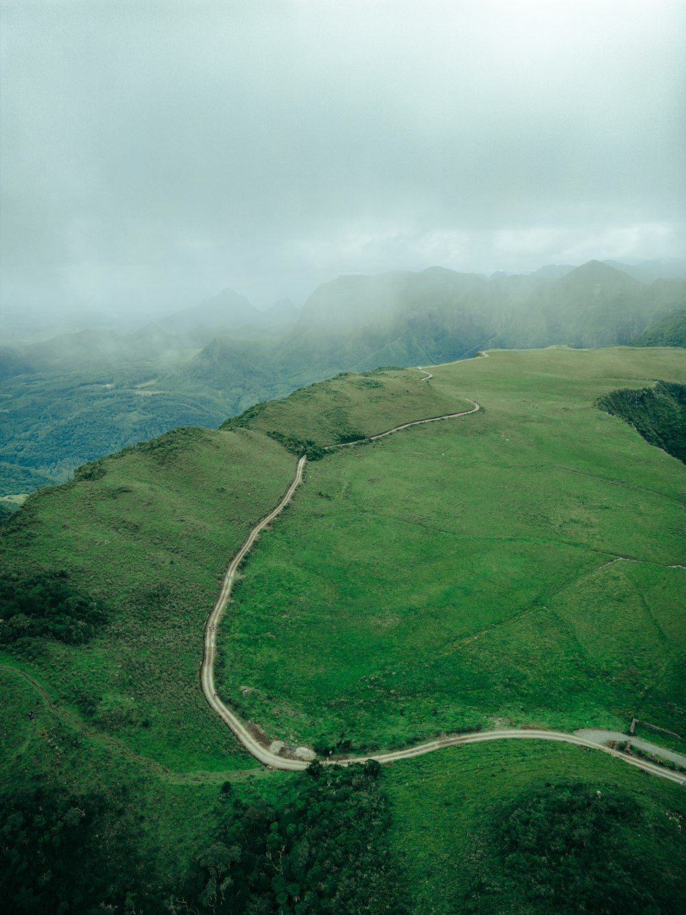 a winding road in the middle of a lush green valley