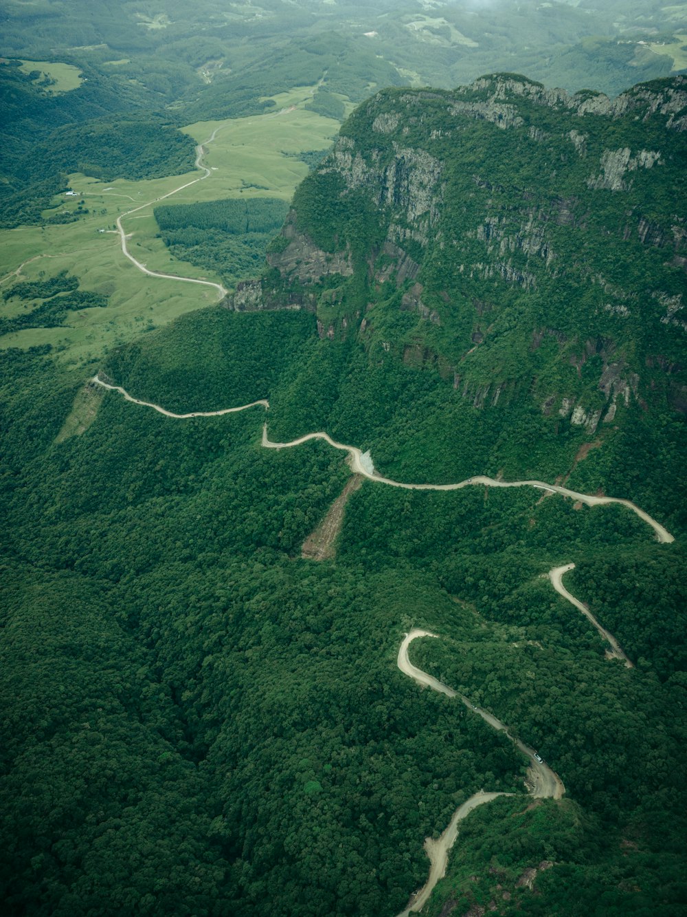 an aerial view of a winding road in the mountains