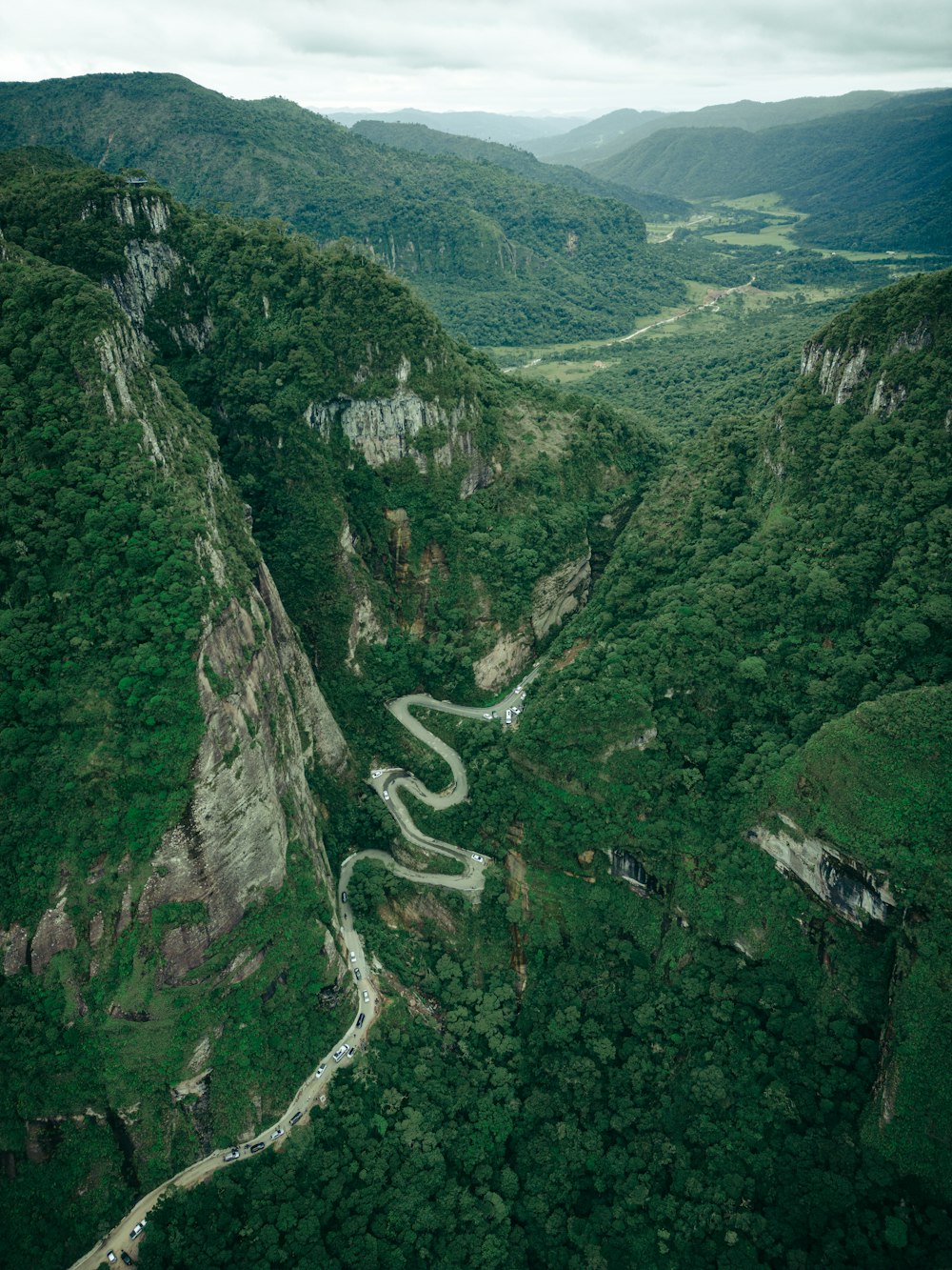 a winding road in the middle of a lush green valley