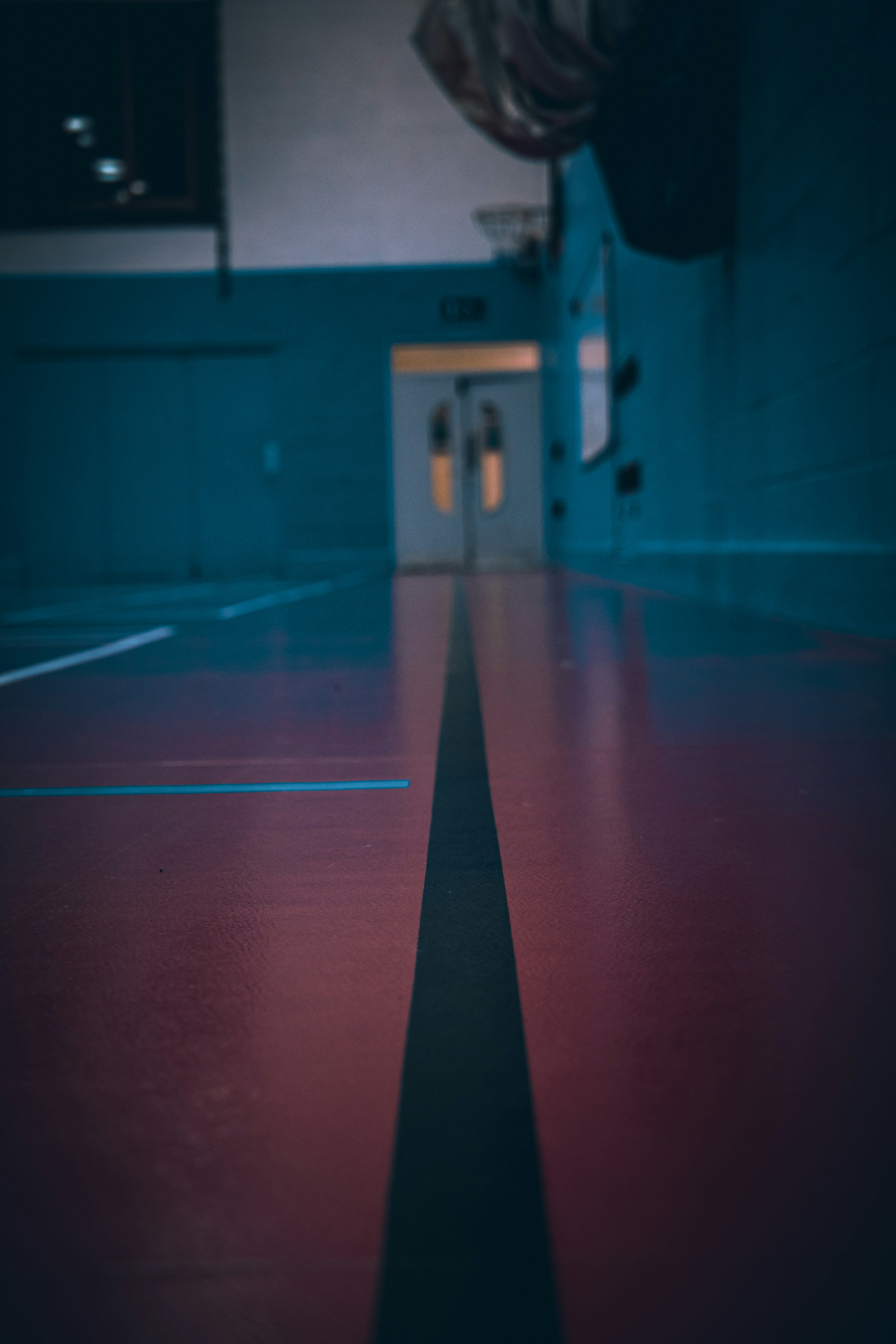 an empty basketball court with a red line on the floor