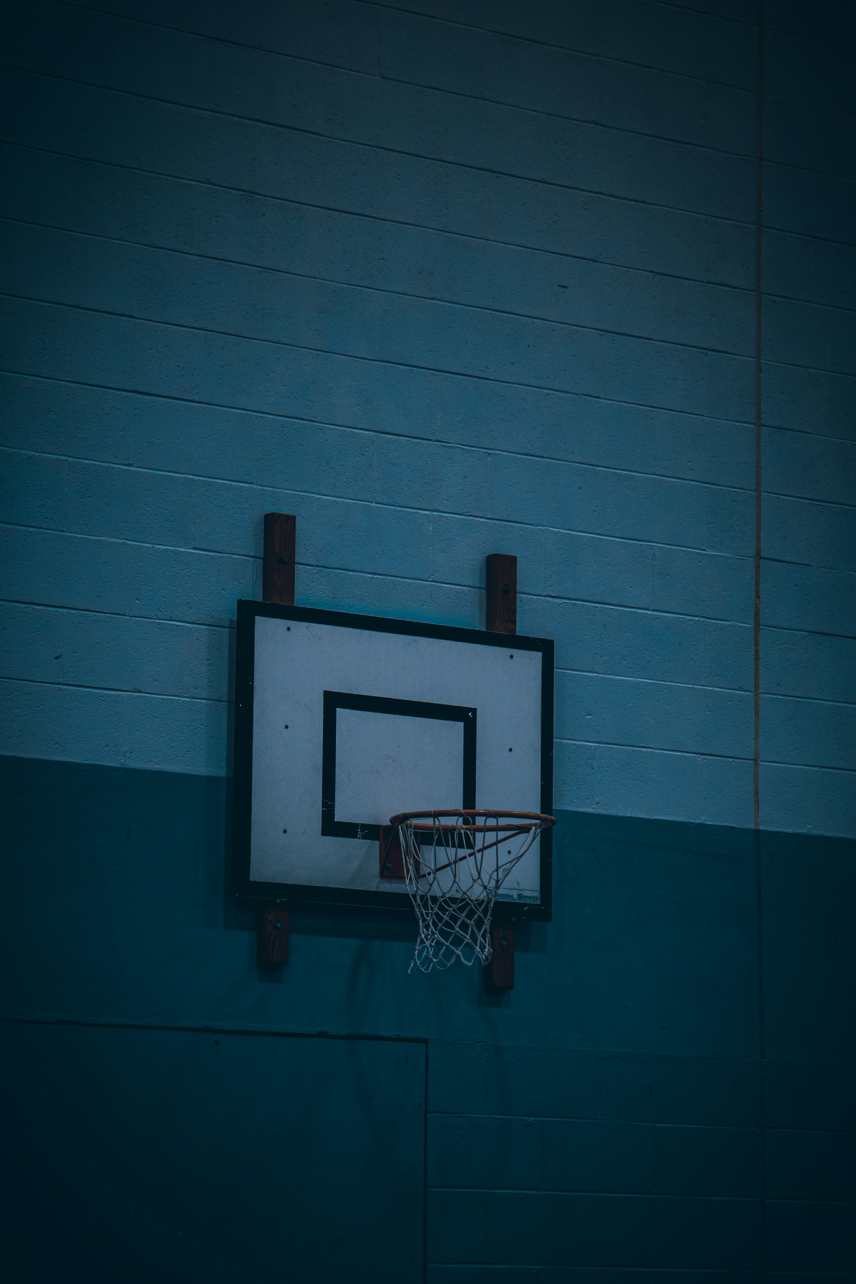 A basketball hoop hanging from the side of a basketball court photo