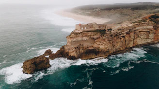 an aerial view of a cliff with a house on top of it