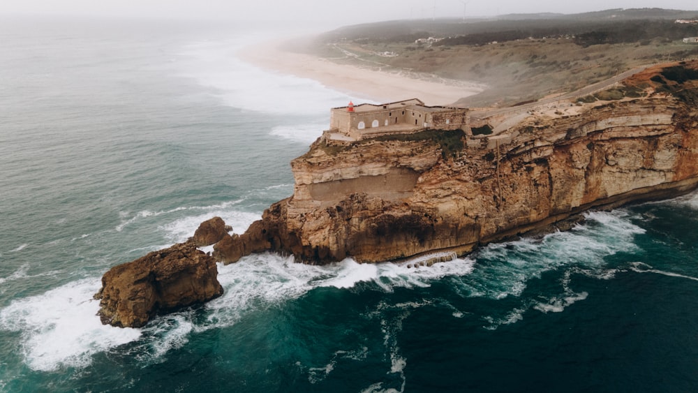 an aerial view of a cliff with a house on top of it