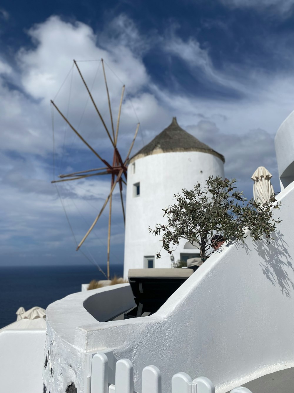 a white building with a windmill in the background