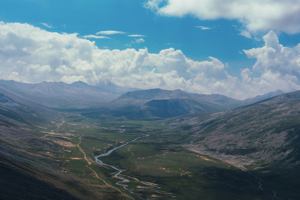 a river running through a valley surrounded by mountains