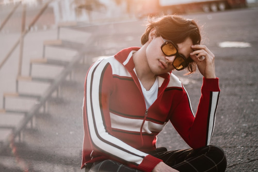 a woman sitting on the ground wearing sunglasses