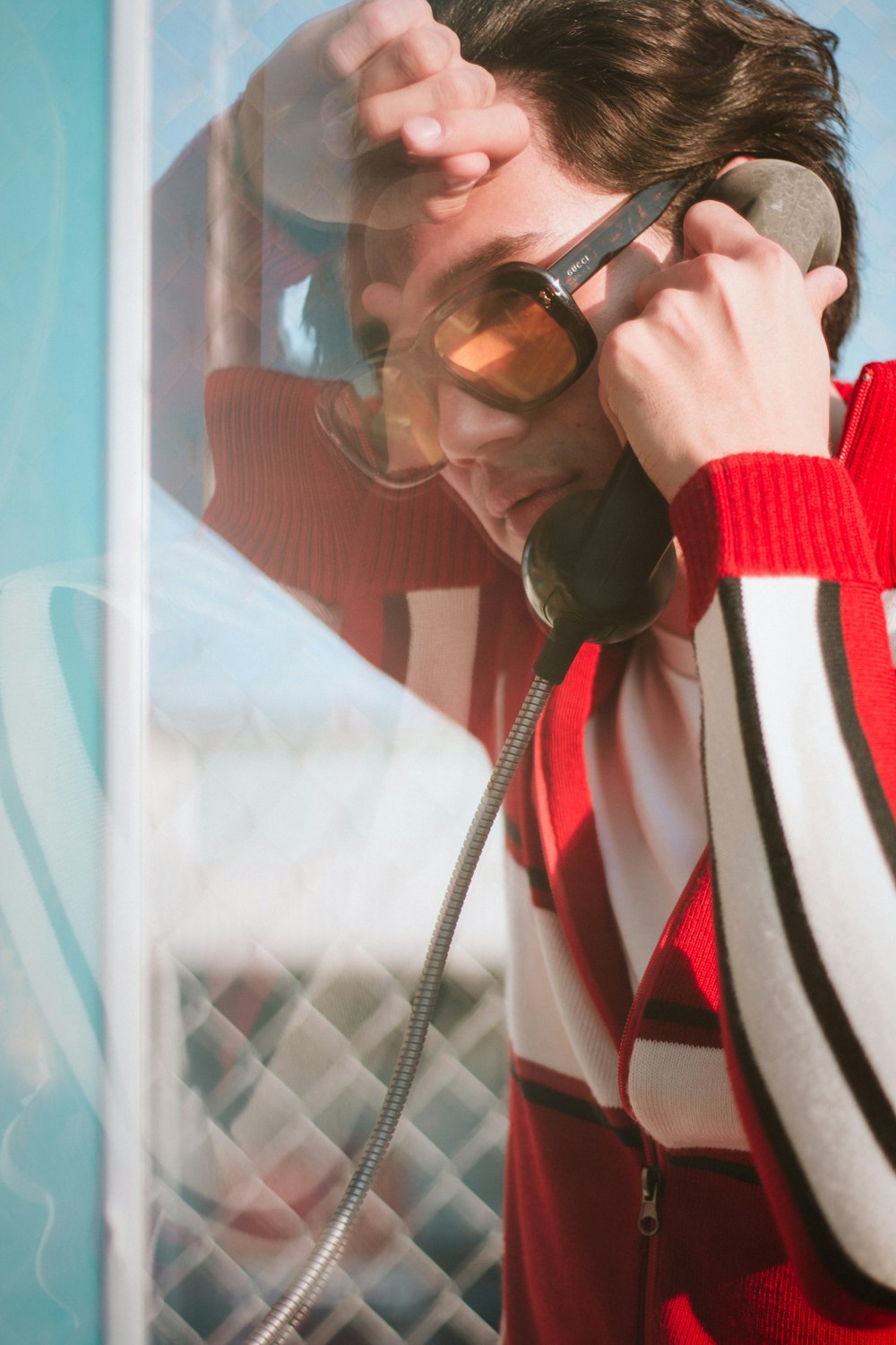 a man talking on a phone while wearing sunglasses