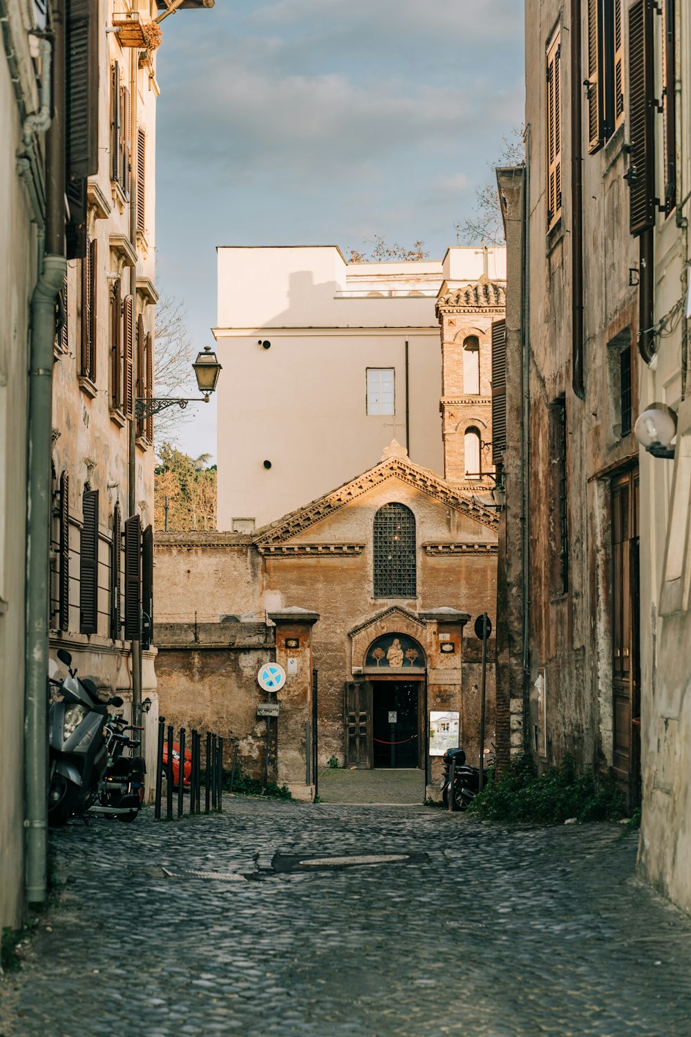 a cobblestone street with a building in the background