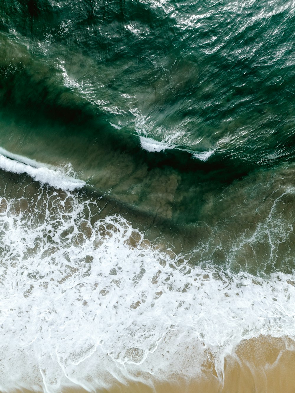 an aerial view of the ocean with waves