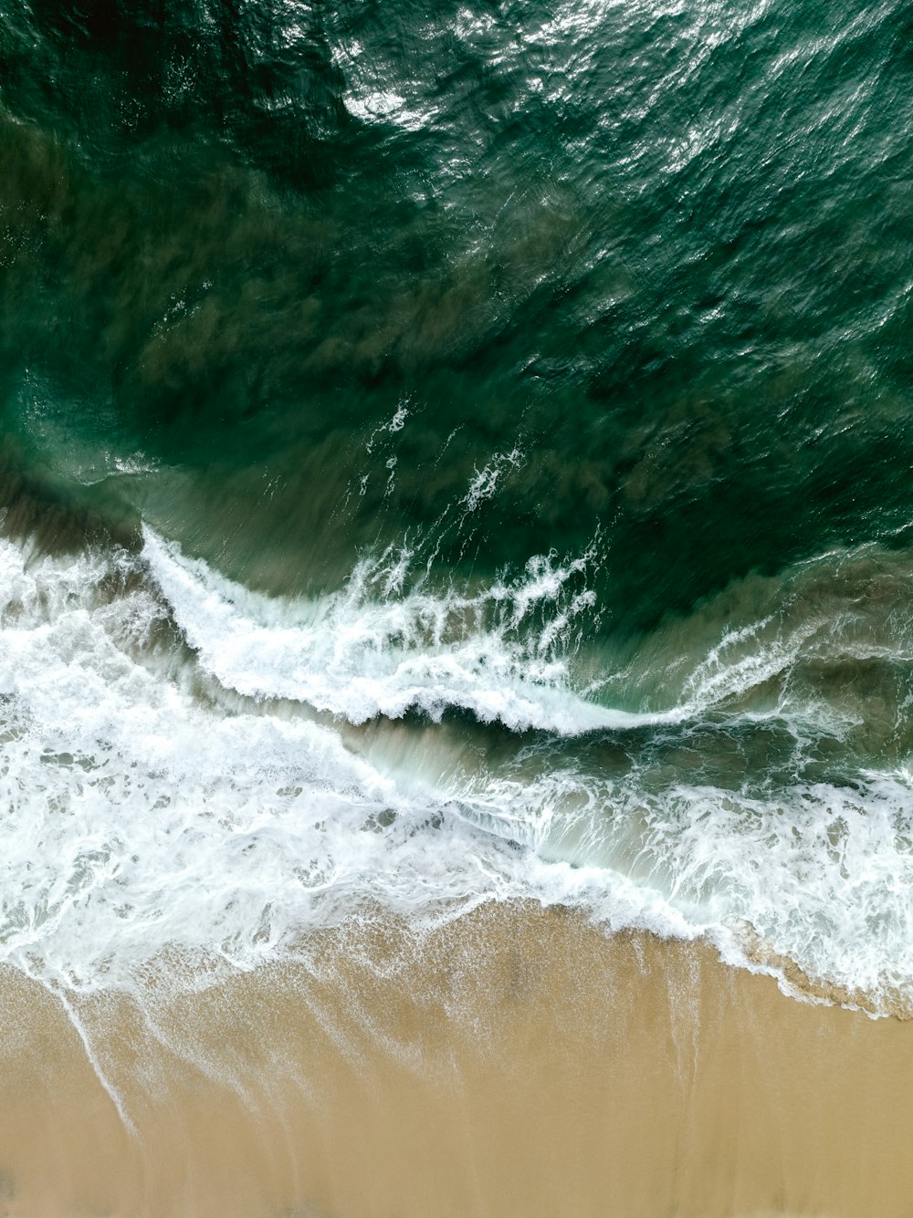 an aerial view of a beach with waves