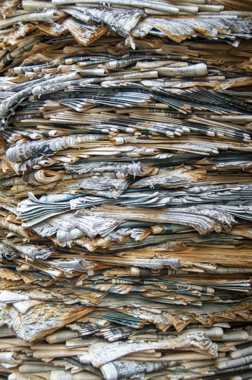 a pile of newspapers sitting on top of a wooden table