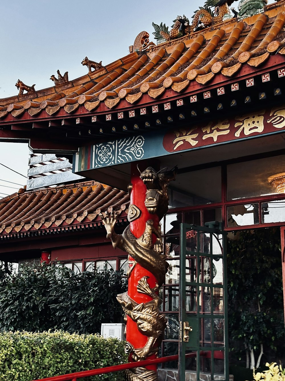 a chinese building with a red and gold vase in front of it