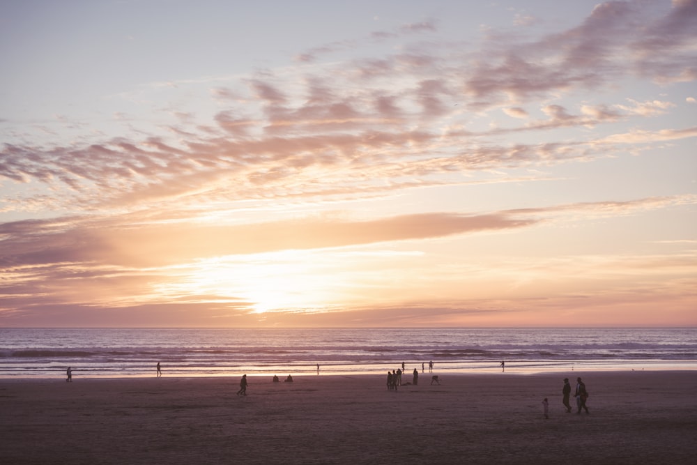 a group of people standing on top of a sandy beach