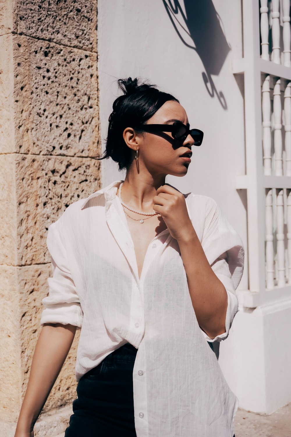 a woman wearing sunglasses and a white shirt