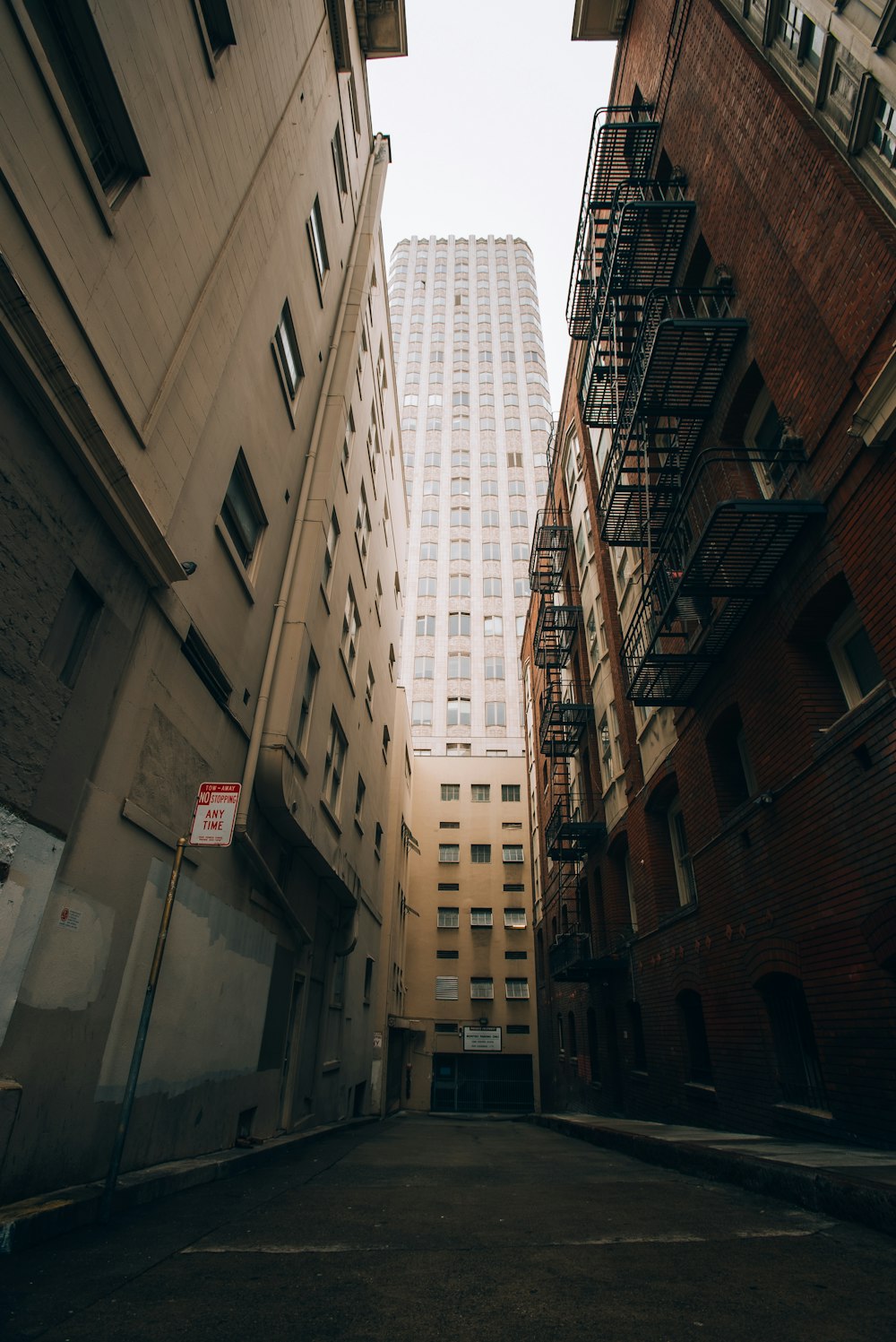 a narrow city street with a tall building in the background