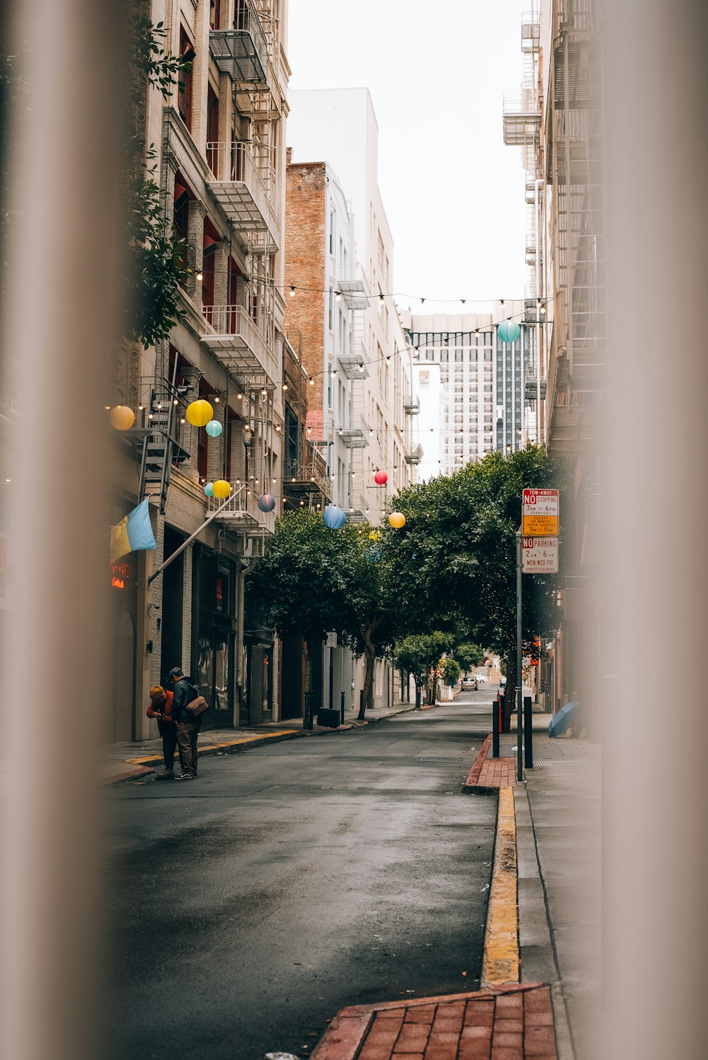 a man riding a motorcycle down a street next to tall buildings