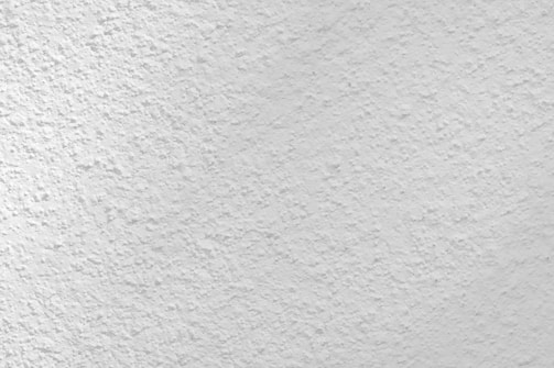 Close-up of a smooth, newly plastered wall with a subtle matte finish.
