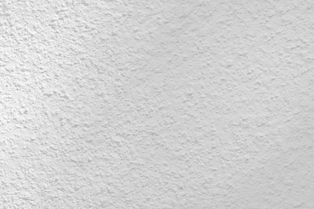 Close-up of a craftsman applying a smooth plaster finish on a modern interior wall.