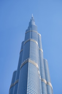 A towering skyscraper gleaming under the sun with spotless glass windows.