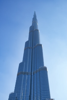 A majestic luxury skyscraper gleaming under a clear blue sky.