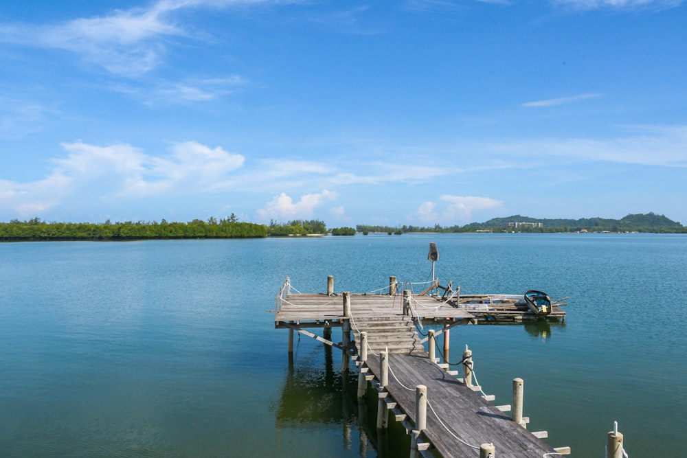 a dock on a lake with a boat in the water