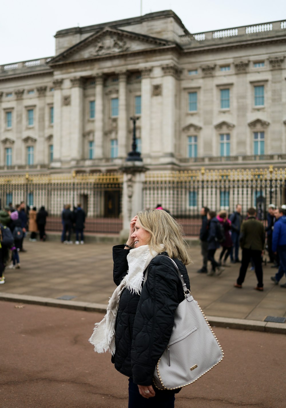 a woman standing in front of a building talking on a cell phone