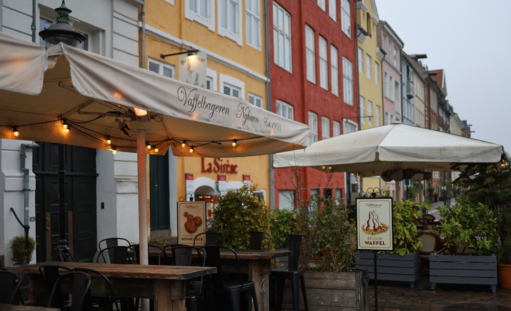 an outdoor cafe with tables and umbrellas on a rainy day