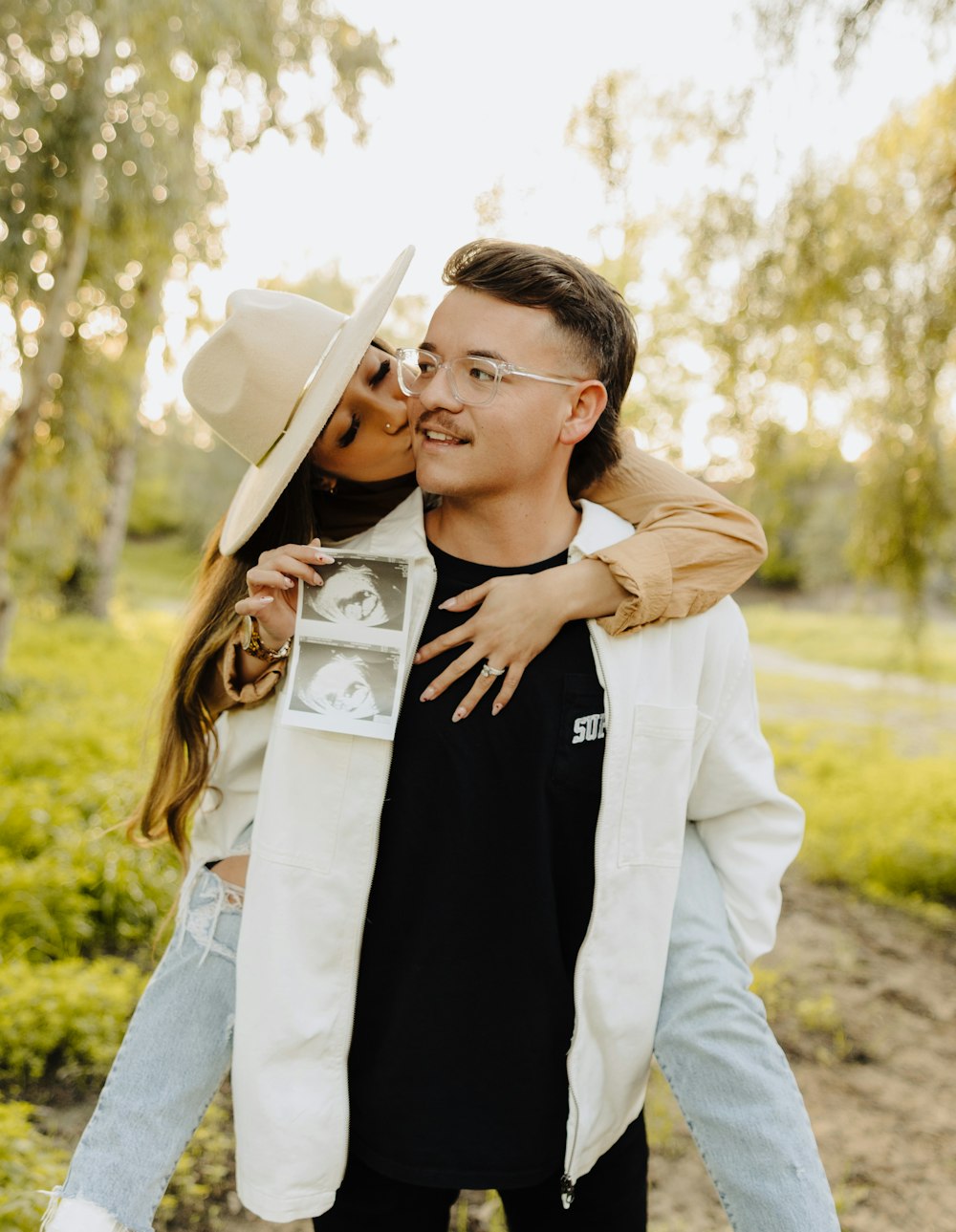 a man and a woman kissing in the park