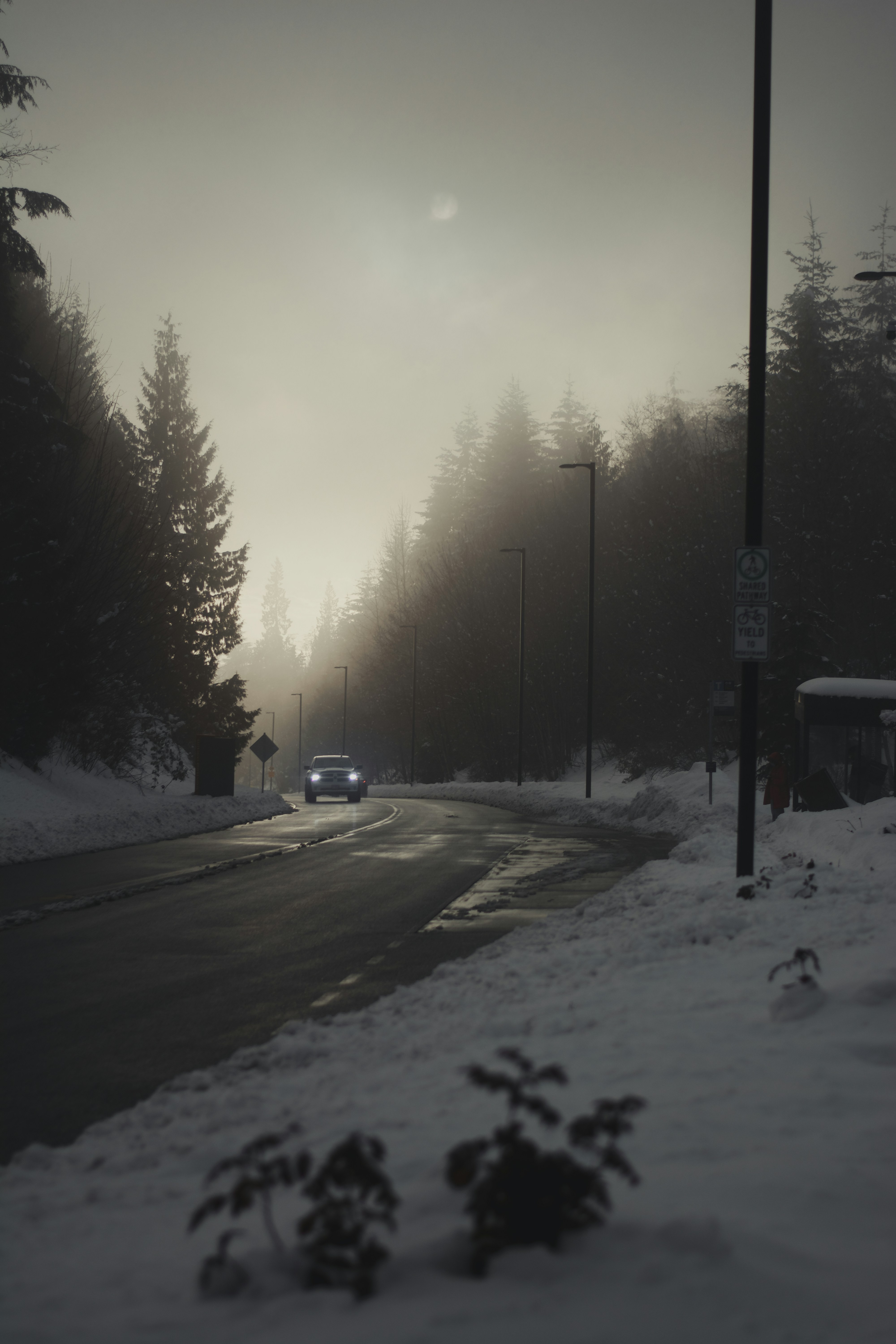 Ein Auto fährt eine schneebedeckte Straße hinunter
