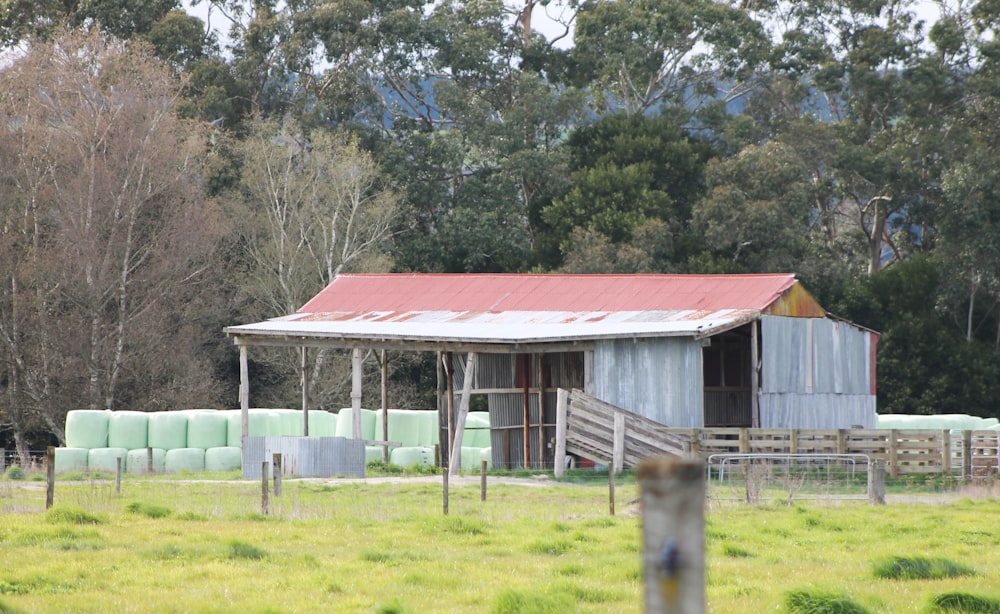 a barn with a red roof in a field