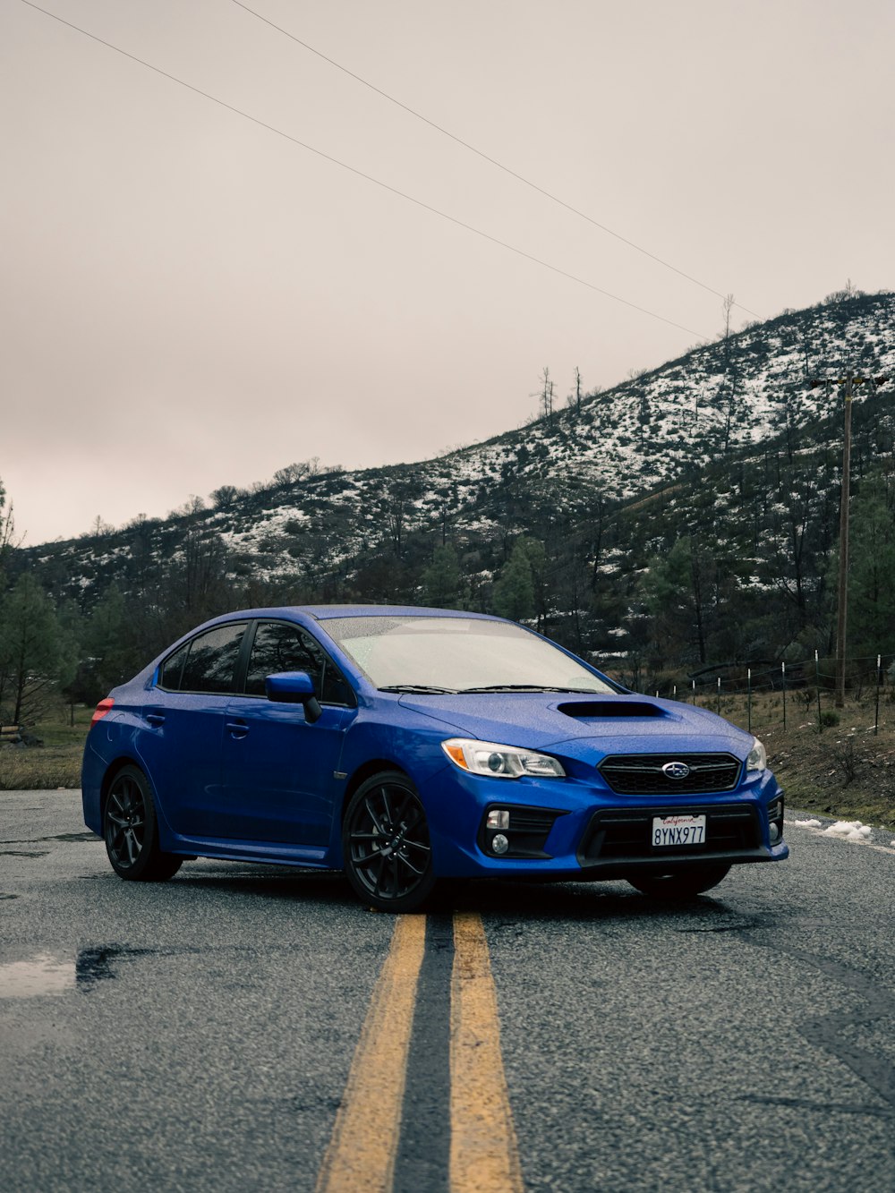 a blue subarunt parked on the side of the road
