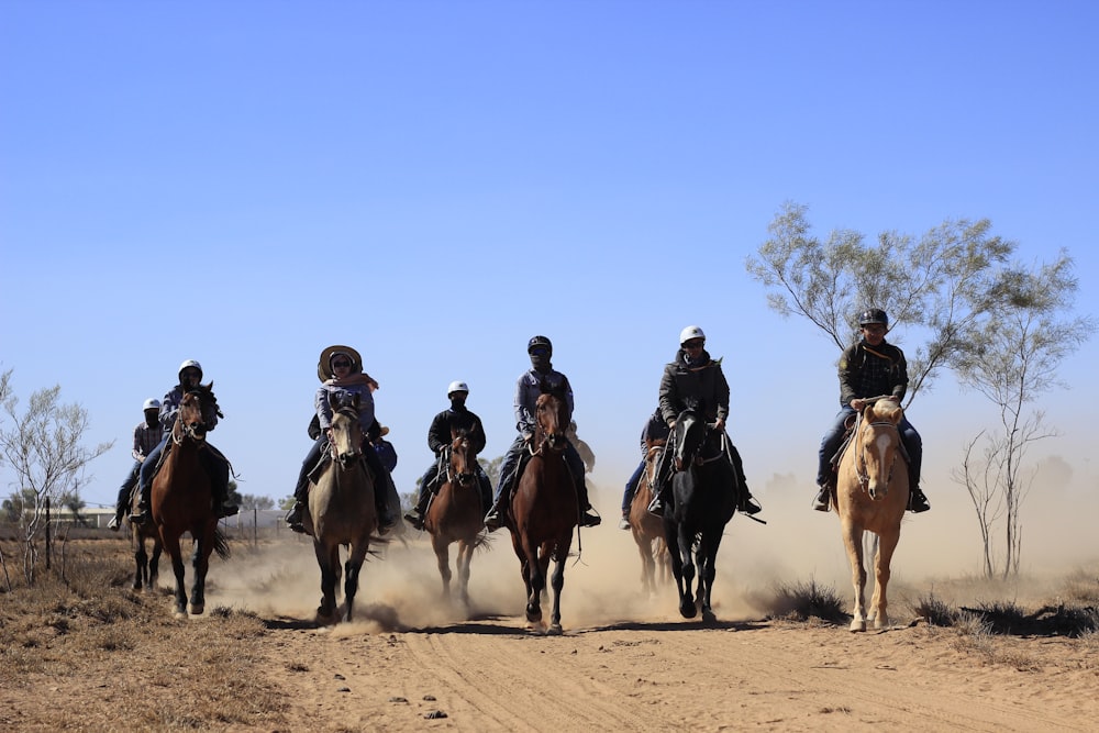 a group of men riding on the backs of horses