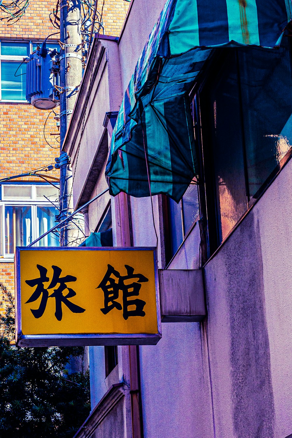 a yellow sign hanging from the side of a building