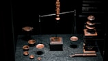 a display case with a scale, cups, and other items